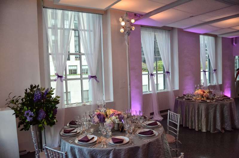 Setup lavender wireless LED Up-Lights around the inside perimeter walls for a wedding at 620 Loft and Garden. Also, set up pin spots on the table centerpieces for a wedding at 620 Loft & Garden.