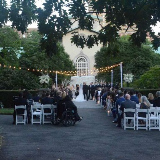 String Lights hanging from lighting stands above an outdoor wedding ceremony at The Brooklyn Botanical Garden.