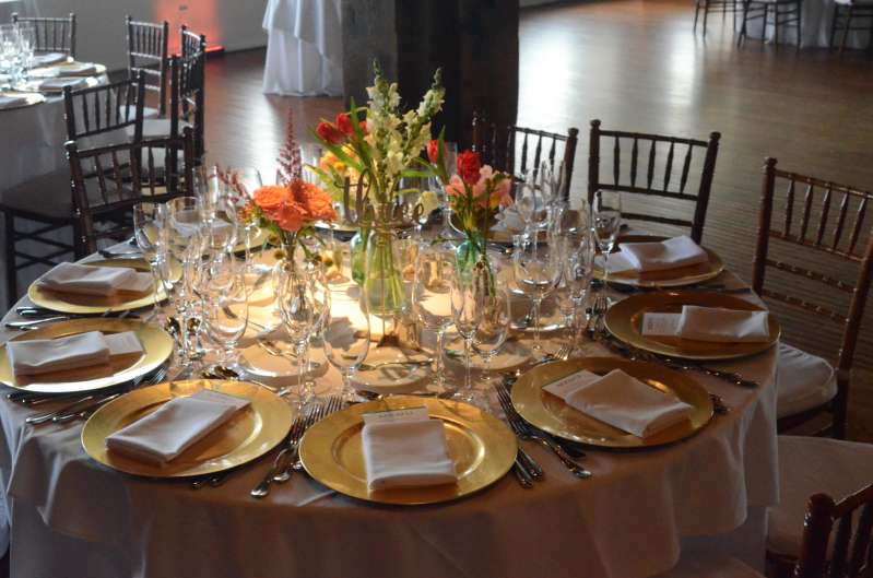 Pin-Spots are highlighting the floral centerpiece at each table.