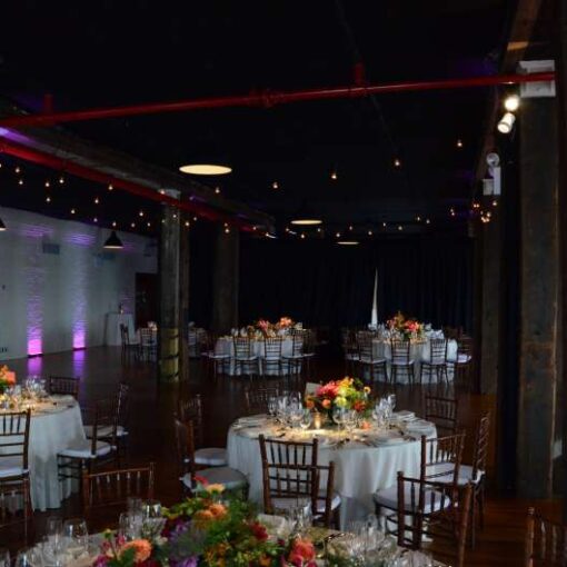 Pin Spots for wedding reception in Harbor Room at Liberty Warehouse in Red Hook (Brooklyn, NY). Also, Wireless Battery Powered LED Up-Lights. In addition, Cafe Lights/String Lights hanging over the dance floor.