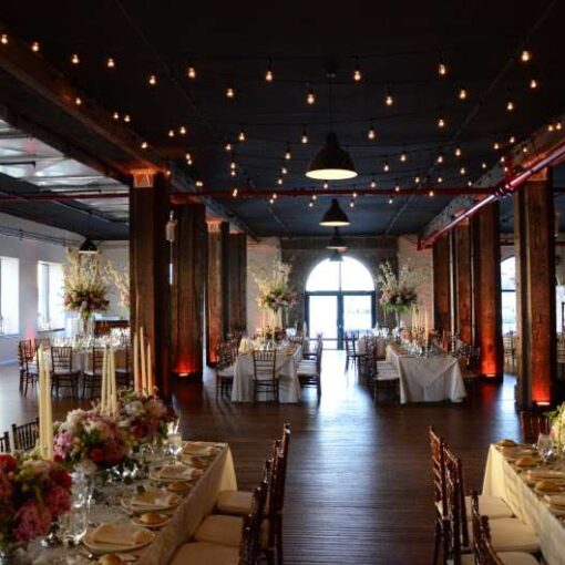 Cafe Light (String Lights/ Bistro Lights) hanging over the dance floor in The Harbor Room at the Liberty Warehouse. Also, Up-Lights around the perimeter of the room and at the base of each column on the first floor.