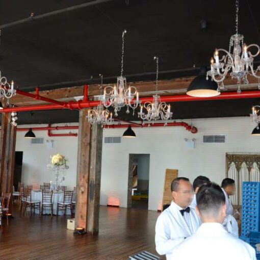 Chandeliers hanging over the dance floor at the Liberty Warehouse. In addition to up-lights around the inside perimeter walls and at the base of each column.