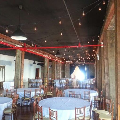 Bistro Lights hanging above the full length of the reception room between the center columns at The Liberty Warehouse.