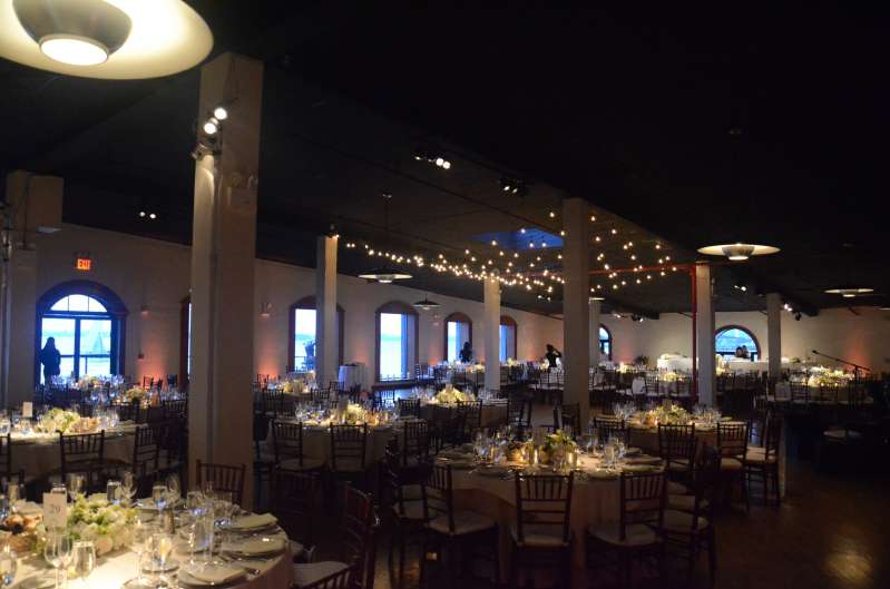 Pin-Spot highlighting the tables and Up-Lights placed around the perimeter wall and String Lights hanging above the dancefloor.