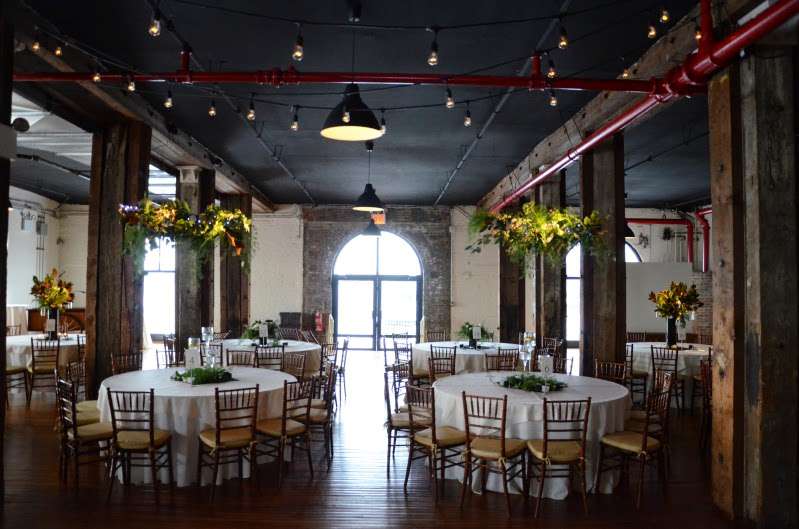 String Lights hanging on both floors at The Liberty Warehouse along with Pin-Spots highlighting the floral arrangements.