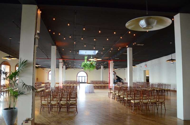 String Lights hanging on both floors at The Liberty Warehouse along with Pin-Spots highlighting the floral arrangements.