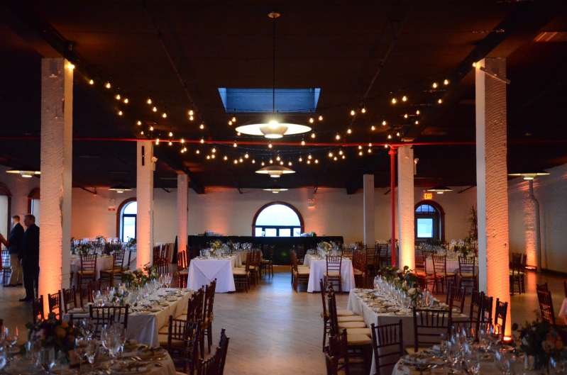String Lights (Bistro/Cafe Lights) hanging above the dance floor at The Liberty Warehouse. Also, Up-Lights around the perimeter of the room and at the base of each column. 