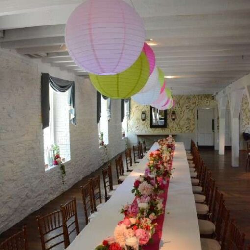 40 Paper Lanterns in various colors hanging in the main room over two rows of banquet tables in The Stone Mill.