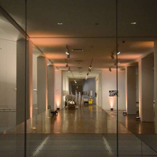 Up-Lights setup against the walls and under the rectangular glass installation hanging above the dinner tables at The Queens Museum.