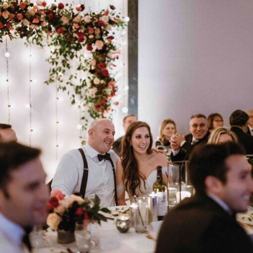 Vertical Warm White String Lights hanging against a wall as a backdrop for a wedding at Dobbin St.
