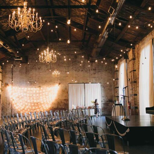 Warm White String Lights with Pendant Lamps hanging in a zigzagging pattern above the main room at The Green Building.