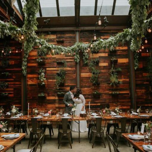 String Lights hanging overhead with additional greenery covering section the String Light cord in The Atrium at The Brooklyn Winery.