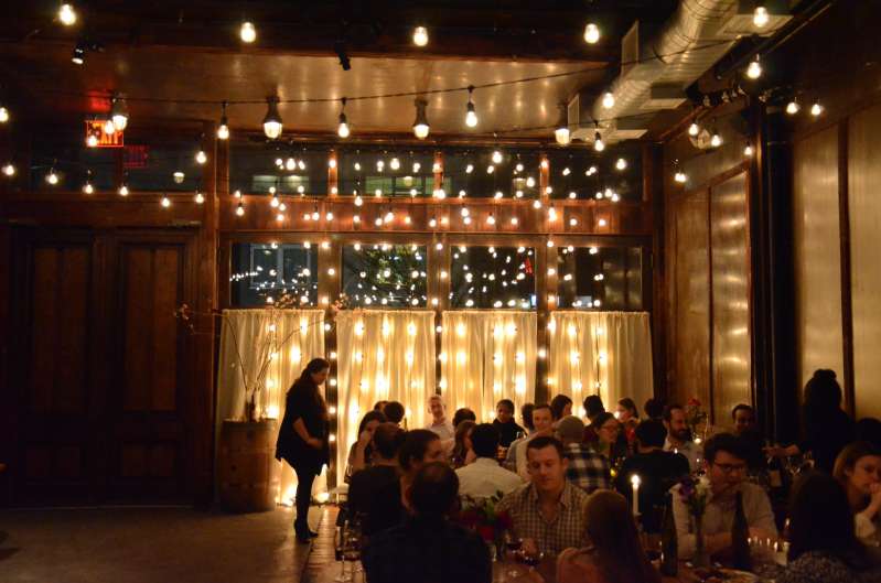 String Lights hanging Vertically as a back drop against the windows that are behind the ceremony area. Also, String Lights with S14 bulbs hanging overhead in The Atrium at The Brooklyn Winery. 