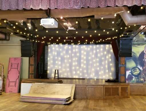 String Lights hanging overhead above the dance floor and vertically against the wall with white drapes at The City Winery.