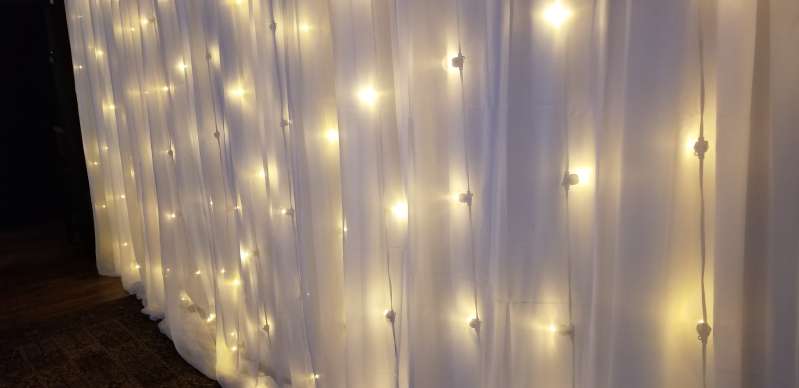 String Lights hanging vertically against the wall with white drapes at The City Winery.