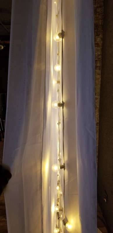 String Lights hanging vertically against the wall with white drapes at The City Winery.