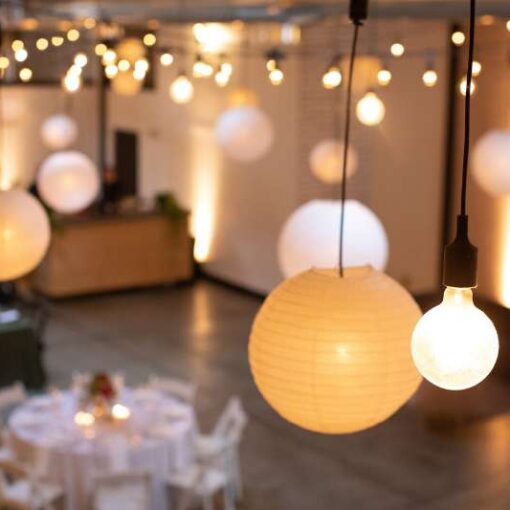 String Lights with Paper Lanterns hanging in a zigzagging pattern above the main floor for a wedding at Dobbin St.