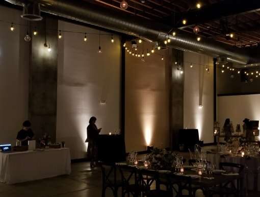 String Lights hanging overhead along with Up-Lights against the perimeter walls or an open house at Dobbin St. Also, a custom gobo projector displaying an image on wall at Dobbin St..