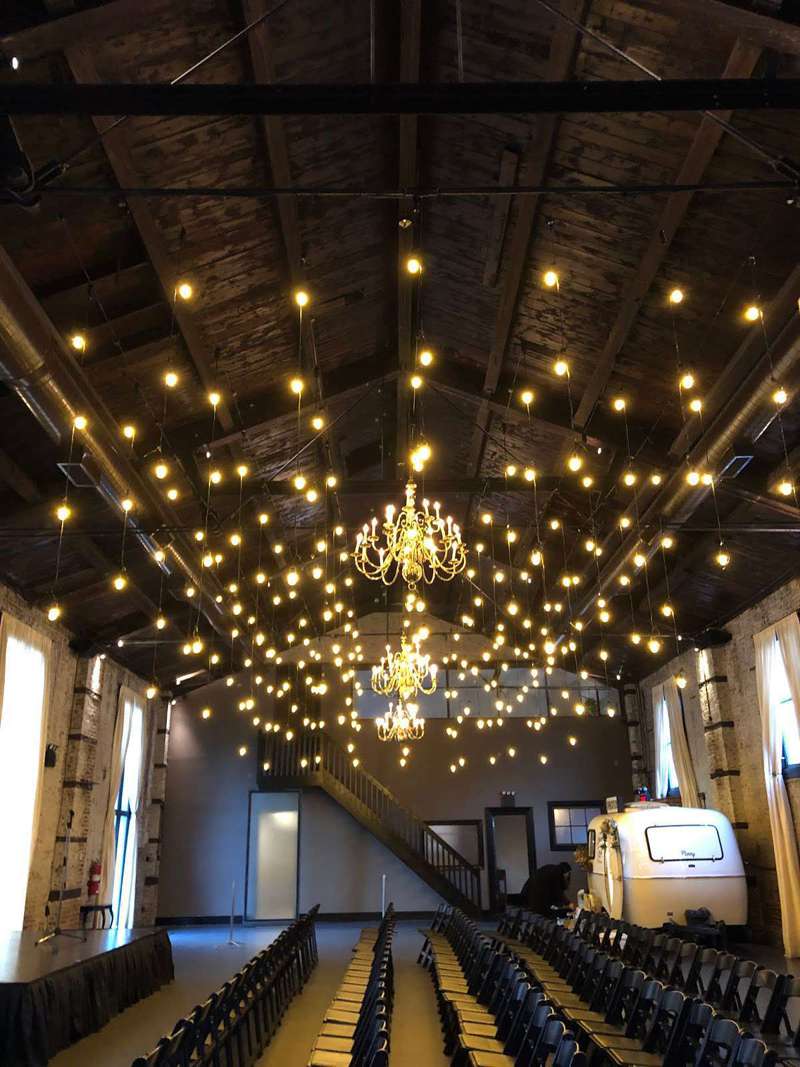 Warm White String Lights hanging overhead vertically as multiple six-foot pendants for Love Union at The Green Building.