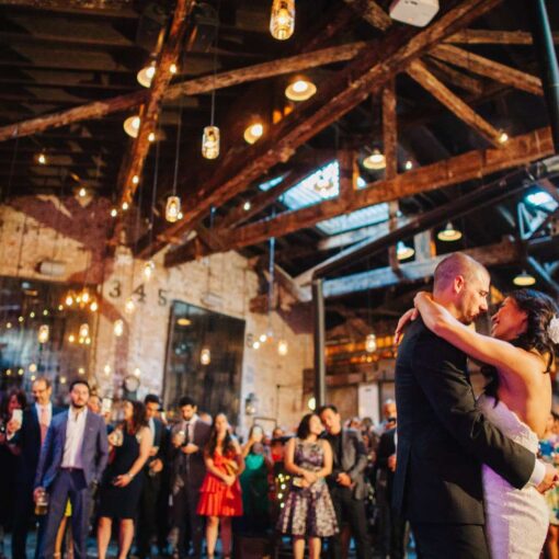 A combination of string lights and pendant lamps with mason jars hanging over the dance floor at The Houston Hall.