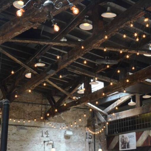 String Lights hanging in a V-Shape and Zigzag pattern over the main room for a wedding at The Houston Hall.