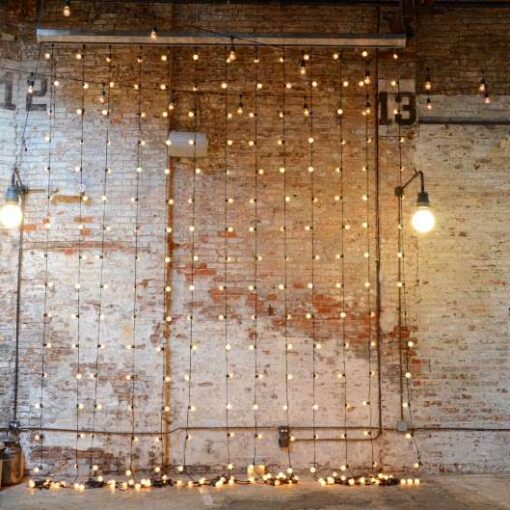 Vertical Curtain of String Lights hanging against the rear wall for a wedding at The Houston Hall.
