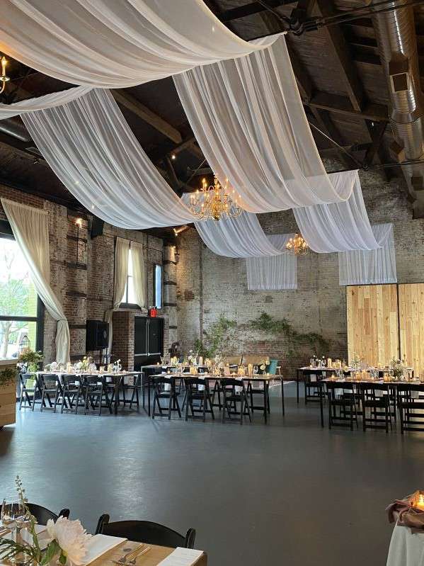 White Sheer drapes hanging in two parallel lines over The Main Room for a wedding at The Green Building.