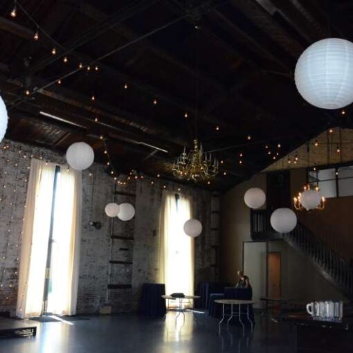 Warm White String Lights with Paper Lanterns hanging overhead for a wedding at The Green Building in Brooklyn, NY.