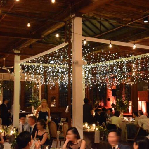 Warm White Icicle Lights/ Fairy Lights hanging over the head table for a wedding at The Metropolitan Building. Also, string lights hanging over the dinner tables and dance floor for a wedding at The Metropolitan Building.