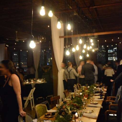 Pendant Lamps with Vintage Antique Edison Bulbs hanging over the Bride/Groom's table at The Metropolitan Building located in Long Island City, NY.  Also, sheer curtains to partition the ceremony area from the remainder of the room.  Finally, String Lights hanging over the majority of the main room (4th Floor).