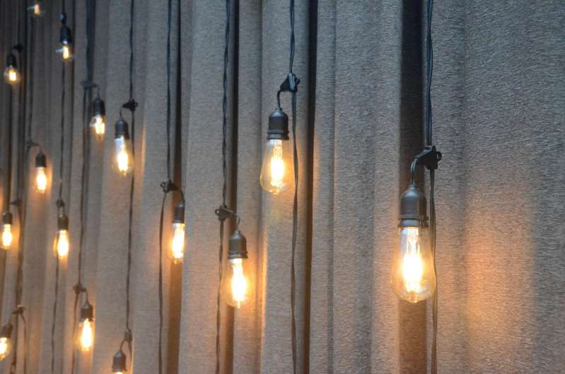 A vertical curtain of string lights hanging as a backdrop against rear dance floor wall at The Tribeca Rooftop.