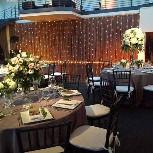 A curtain of vertical string lights hanging against the wall at rear of the dance floor at The Tribeca Rooftop.