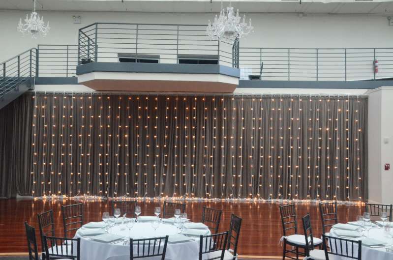 String Lights with round G50 bulbs hanging vertically as a curtain of lights for a wedding at The Tribeca Rooftop.