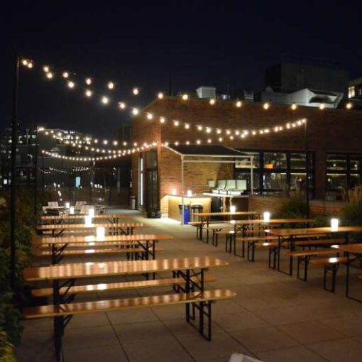 String Lights hanging from stands above the rooftop of The Arlo Hudson Square for the NY Food and Wine Chef's After Party.
