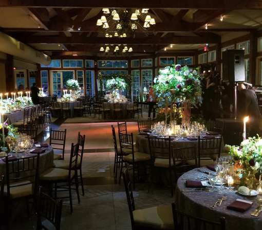 Pin-spots hanging overhead for the table centerpieces at a wedding reception at The Central Park Boathouse in New York City.
