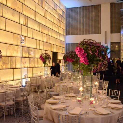Pin-spots hanging from lighting stands to highlight the table centerpieces in the Onyx Room at The Park Hyatt Hotel (New York).