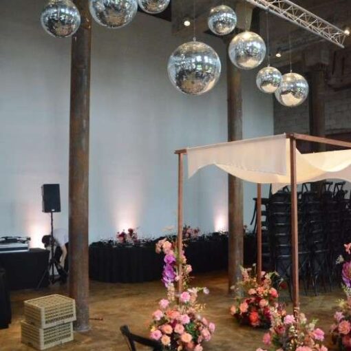 Multiple Mirror Balls hanging above the main floor at The Smack Mellon Gallery along with Up-Lights along the perimeter walls.