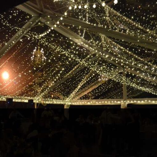 A Canopy of Mini String Lights for a wedding reception under a clear top tent at The New Leaf Cafe inside Fort Tryon Park in New York City.