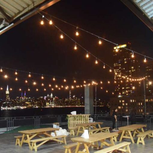 String Lights hanging ins a zigzag pattern from stands above the outdoor rooftop terrace at The W-Loft in Brooklyn, NY.
