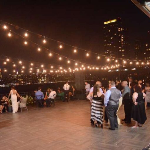 String lights hang outdoors from the lighting stands above the rooftop terrace for a wedding at The W-Loft.