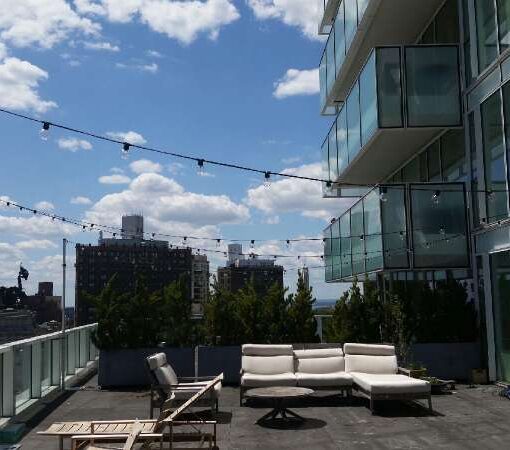 String Lights hanging from lighting stands over a private outdoor terrace at 1 Grand Army Plaza (Brooklyn, NY).