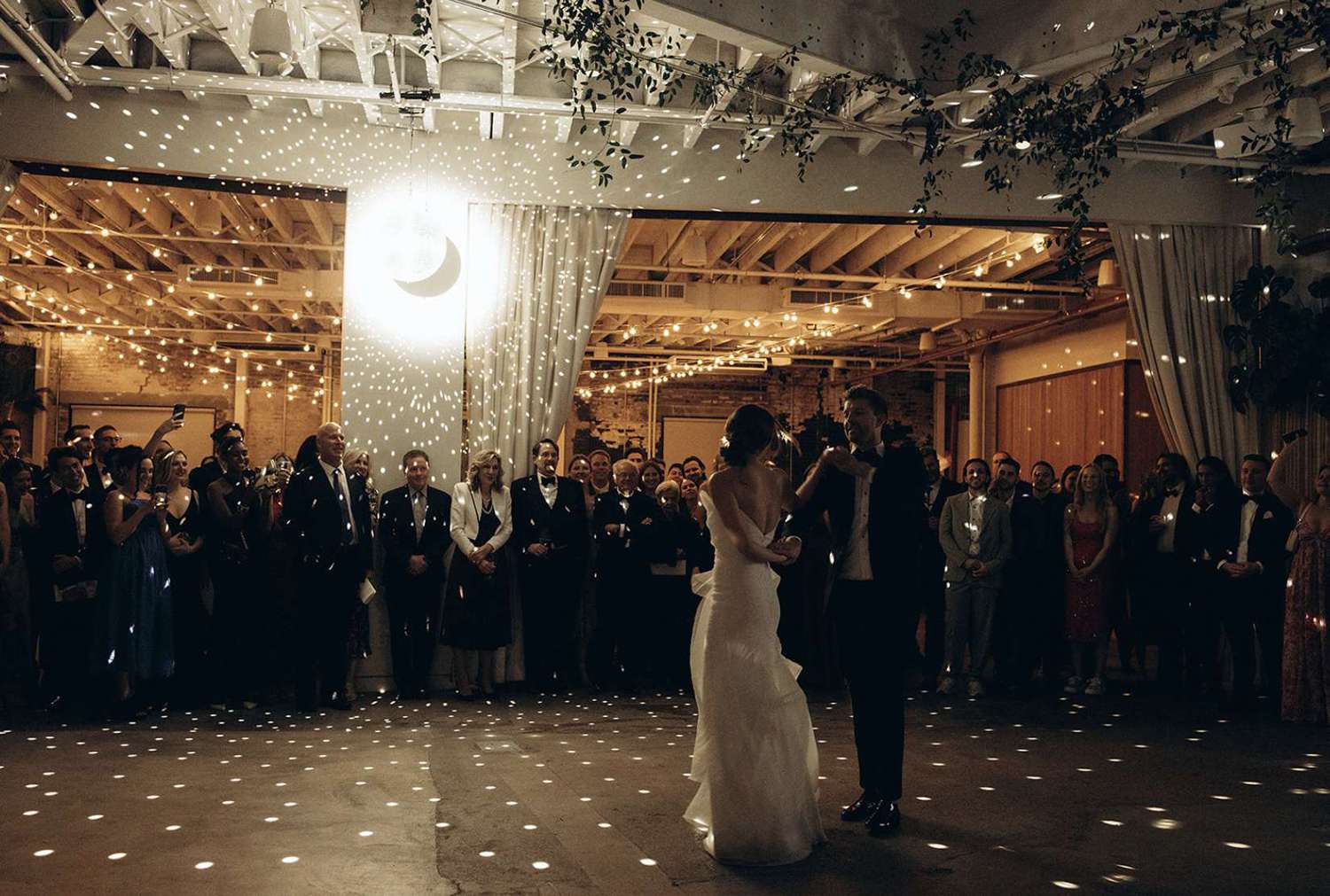 A rotating mirror ball with one spotlight hanging at the edge of the dance floor in The Atrium at The Rule of Thirds in Brooklyn, NY.