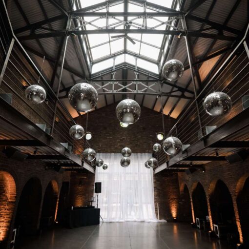 Multiple Mirror Ball hanging in the main reception room and Up-Lights at The Found for Kim & Mert’s wedding - June 1st, 2025