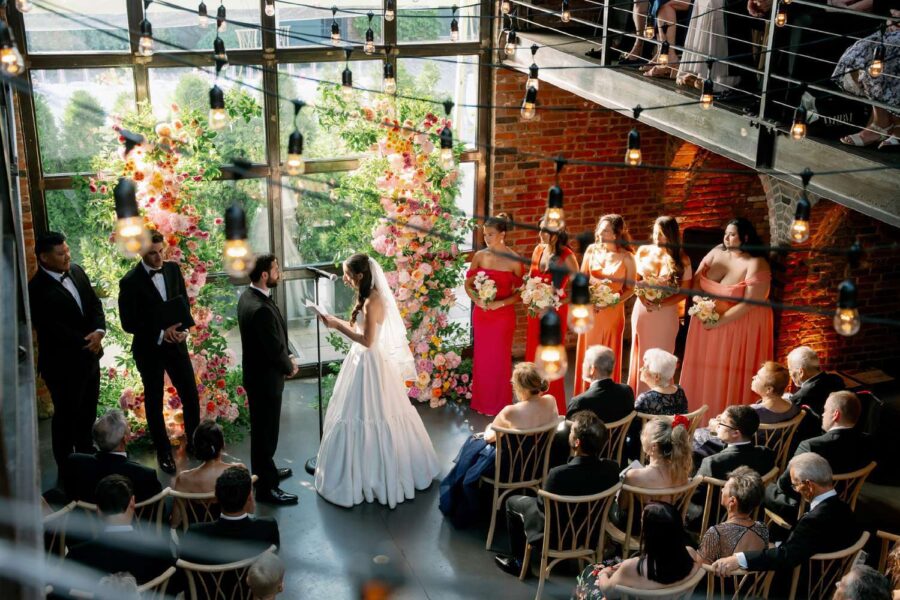 Gianna + Steven's wedding ceremony inside the main reception room with String Lights hanging overhead for their summer wedding at The Foundry
