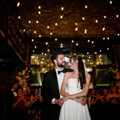String Lights hanging overhead in the main reception room for Gianna + Steven's first dance at their summer wedding reception at The Foundry.