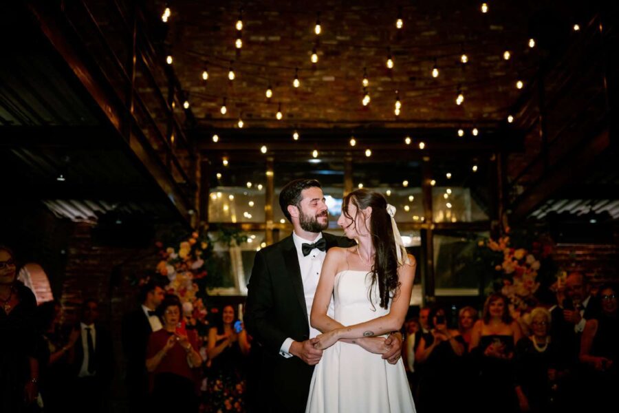 String Lights hanging overhead in the main reception room for Gianna + Steven's first dance at their summer wedding reception at The Foundry.