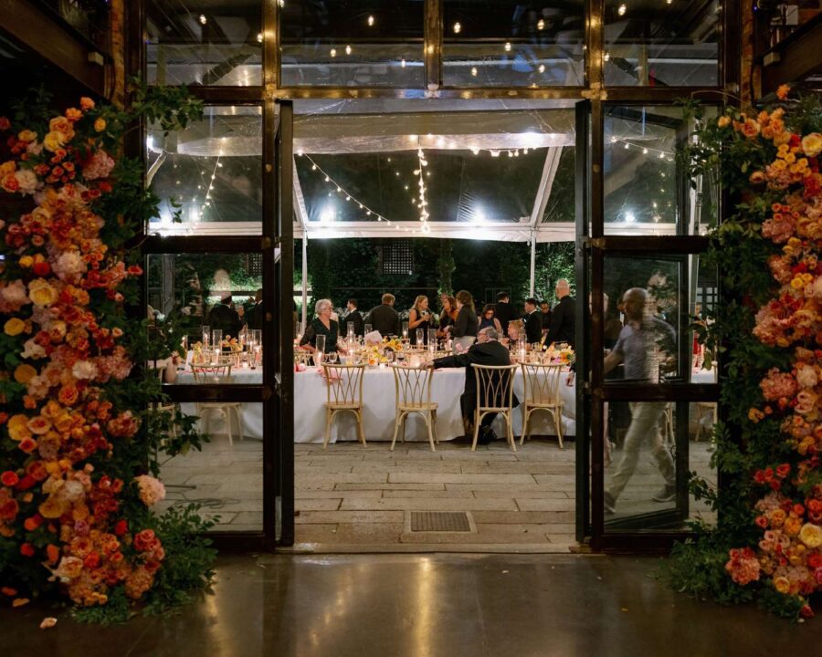 A summer wedding reception under a clear top tent with String Lights hanging overhead in the courtyard at The Foundry