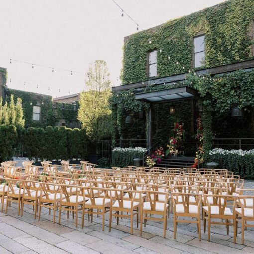 Ceremony chairs in the courtyard for Tina & Real's outdoor NYC wedding reception at The Foundry with String Lights hanging overhead.