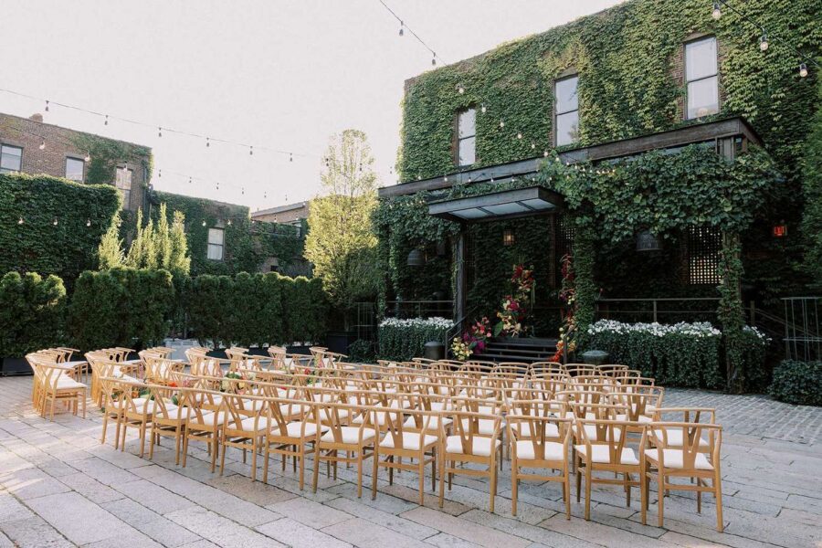 Ceremony chairs in the courtyard for Tina & Real's outdoor NYC wedding reception at The Foundry with String Lights hanging overhead.