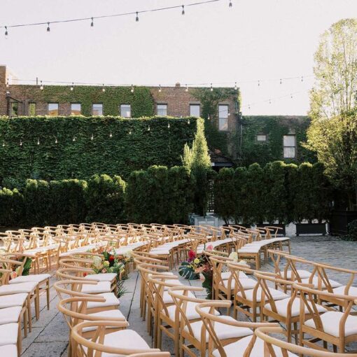 Ceremony chairs in the courtyard for Tina & Real's outdoor NYC wedding reception at The Foundry with String Lights hanging overhead.